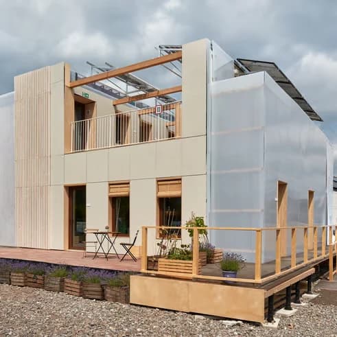 Fachada de Escalà, con revestimiento de madera, cubierta fotovoltaica y terraza con jardineras de lavanda.